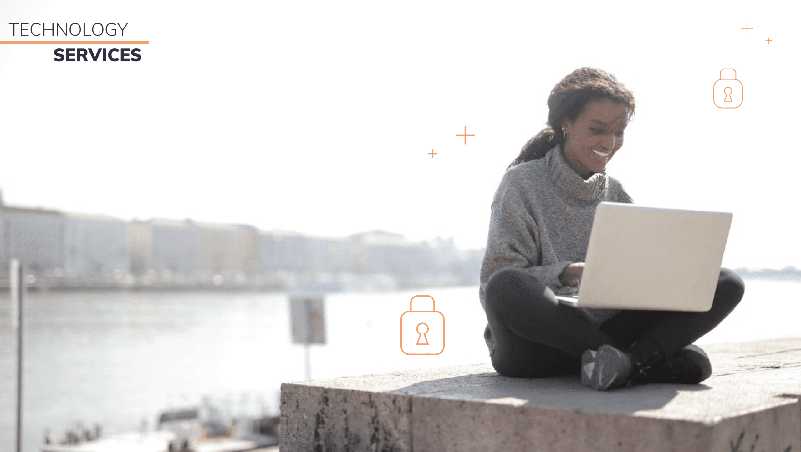 Image of woman sitting by water on her laptop.