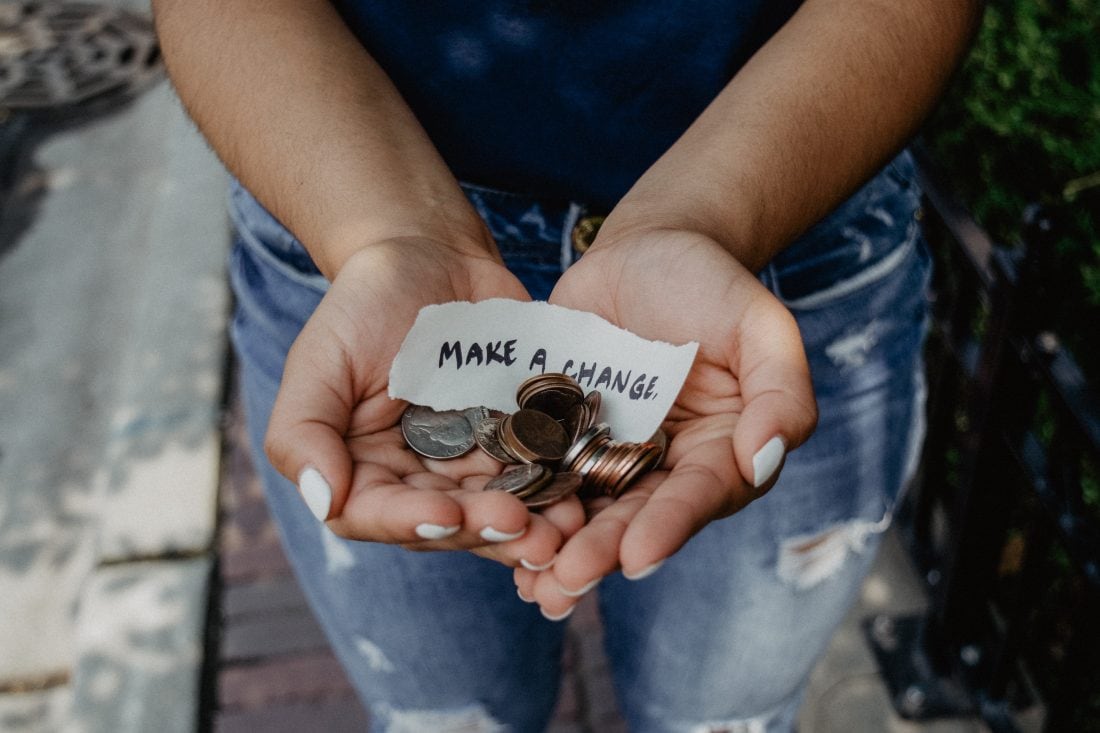 Women holding change in her hand with a note "Make A Change"
